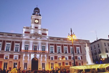 Madrid Topluluğu Başkanlığı binasının ön cephesi (İspanyolca: Presidencia de la Comunidad de Madrid). Gün batımında Plaza del Sol 'da aydınlık cephe, Madrid, İspanya.