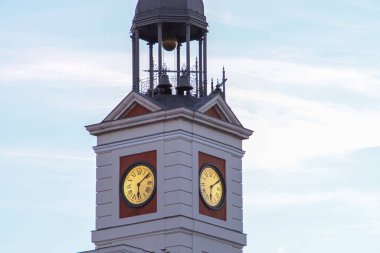 Puerta del Sol Meydanı 'ndaki ana binanın kulesindeki saat. Gün batımında, Madrid Topluluğu 'nun şu anki başkanlığı olan postanenin sarayında elleri aydınlandı..