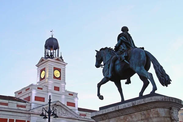 マドリード スペインのコミュニティの現在の大統領 パラシオ コレオスの時計 王立郵便局宮殿の隣のソル広場にあるカルロス3世の騎馬像 — ストック写真