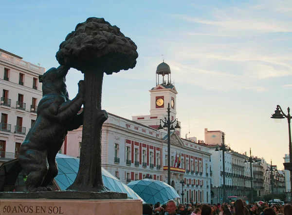 スペインのマドリード 2018年3月11日 プラザ ソルのクマとイチゴの木の彫刻 背景にその時計塔とマドリードのコミュニティの議長の建物のファサード — ストック写真