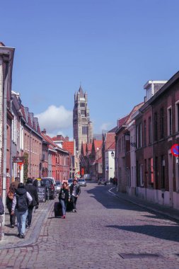 Bruges, Belçika; 04 28 2016. Oostmeers caddesindeki turistler ve arka plandaki ana Bruges kilisesi olan St. Salvator Katedrali..