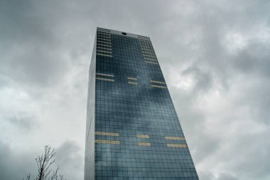 Brüksel, Belçika; 04 29 2016. Brüksel 'deki Federal Emeklilik Hizmetleri Binası. Bulutlu gökyüzü binanın yüzeyine yansıdı..