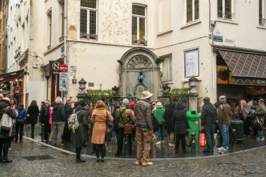 Brüksel, Belçika; 04 29 2016. Brüksel 'deki ünlü Manneken Pi Heykeli' ni ziyaret eden turistler. Geleneksel kostümlü bir heykel ve turistler onun fotoğraflarını çekiyor..