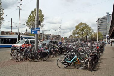 Amsterdam, Hollanda; 04: 30 2016. Centraal İstasyonu 'nun (Amsterdam Merkez İstasyonu) önünde park edilmiş bisikletler, şehrin gerçek merkezindeki ana tren istasyonudur. Çok kullanılmış ve ekolojik taşımacılık.
