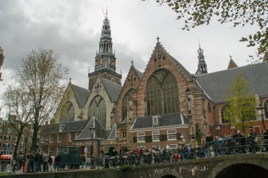 Amsterdam, Hollanda; 04: 30 2016. Amsterdam 'da arka planda Oude Kerk (İngilizce: The Old church) ile Kraliçe Günü Festivali. Amsterdam 'daki birçok kiliseden birinin yanındaki şehir manzarası.