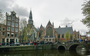 Amsterdam, Hollanda; 04: 30 2016. Amsterdam 'da arka planda Oude Kerk (İngilizce: The Old church) ile Kraliçe Günü Festivali. Amsterdam 'daki birçok kiliseden birinin yanındaki şehir manzarası.