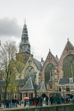 Amsterdam, Hollanda; 04: 30 2016. Amsterdam 'da arka planda Oude Kerk (İngilizce: The Old church) ile Kraliçe Günü Festivali. Amsterdam 'daki birçok kiliseden birinin yanındaki şehir manzarası.