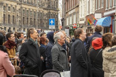 Amsterdam, Hollanda; 04: 30 2016. Beklenen bir kalabalık, Amsterdam 'ın merkezindeki bir binanın tepesinden büyük nesneler atan bir baş belasını izliyor. İnsanlar etkinliği umutla izliyor.
