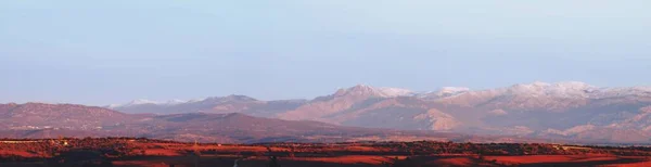 从马德里市北部看到的瓜德拉马山脉在黎明时分 冬日雪山的峰顶 以及初露曙光的粉红 — 图库照片