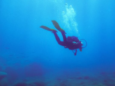 Altta dalgıç ve derin mavi su. Dalgıç Puerto Mogan, İspanya 'da hava kabarcıkları şeklinde dışarı atıyor.