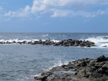 İspanya 'nın Gran Canaria Adası' ndaki El Puertillo kasabasının kıyı manzarası. Volkanik kayalıklardaki dalgaların oluşturduğu engebeli bir manzara..
