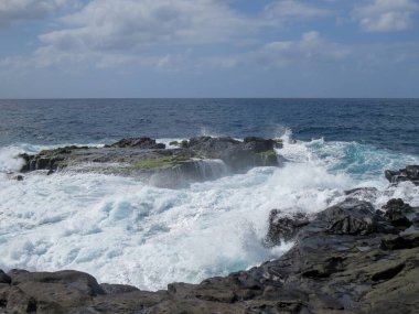 İspanya 'nın Gran Canaria Adası' ndaki El Puertillo kasabasının kıyı manzarası. Volkanik kayalıklardaki dalgaların oluşturduğu engebeli bir manzara..