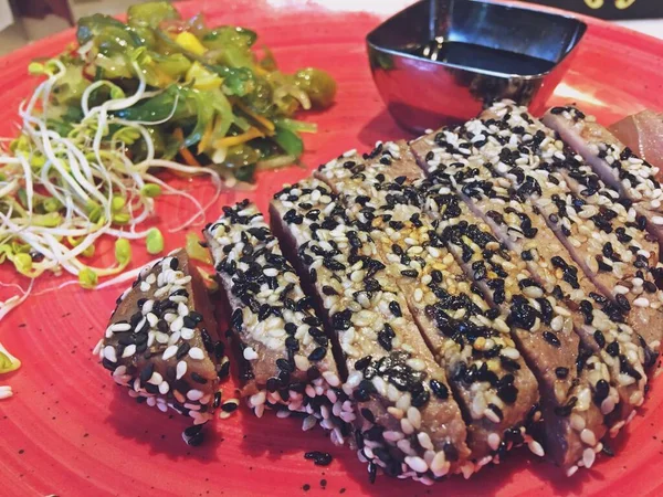 Susamlı ızgara ton balığı ve soya sosu. Lokantada servis edilen ve yemeye hazır yiyeceklerin yakın çekimi..