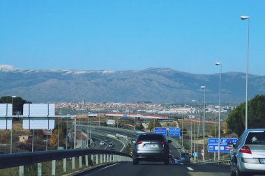 Tres Cantos, İspanya. 12 06 2018. M607 otoyolunda kuzeye doğru giden arabalar. Arka planda Tres Cantos ve Sierra de Guadarrama kasabaları var..