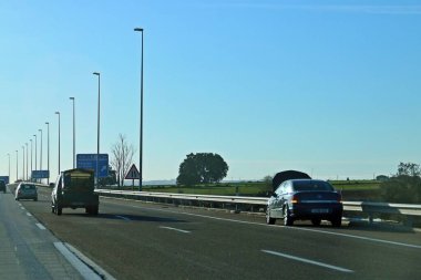 Madrid, İspanya. 02 16 2019. Madrid 'den Valencia' ya giden A-3 otoyolunda bozulmuş bir araba. Kapüşonlu, sert omuzlu, bozuk arabanın yanında giden arabalar..