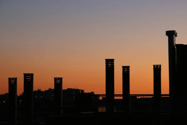 Silhouette Von Schornsteinen Bei Sonnenuntergang Rötlicher Himmel Und Schornsteine Eines — Stockfoto