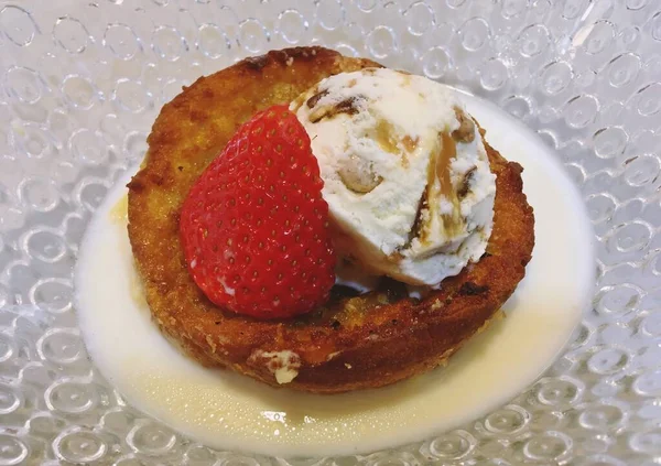 Torrija, typical Easter sweet in Spain served with strawberry and ice cream. Sweet made with bread soaked in milk, coated in egg, fried in extra virgin olive oil and coated in sugar.
