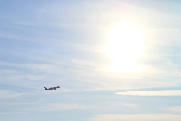 アドルフォ スアレス マドリード バラハス空港から離陸する旅客便のシルエット 遠く暗いシルエットで 太陽が澄んだ空に背景に輝いている — ストック写真