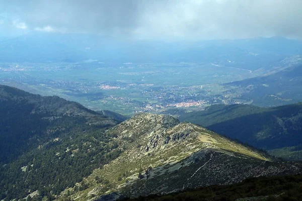 Cercedilla and the ridge known as Cuerda de las Cabrillas in Madrid, Spain. View from the path that leads to the top of La Bola del Mundo in spring.