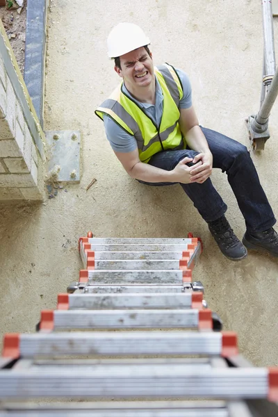 Obrero de la construcción cayendo de la escalera e hiriendo la pierna — Foto de Stock