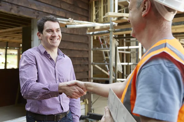 Cliente apertando as mãos com construtor — Fotografia de Stock