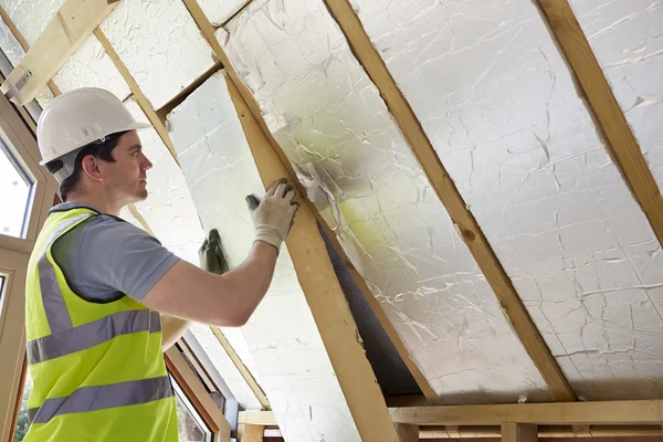 Builder Fitting Insulation Into Roof Of New Home — Stock Photo, Image