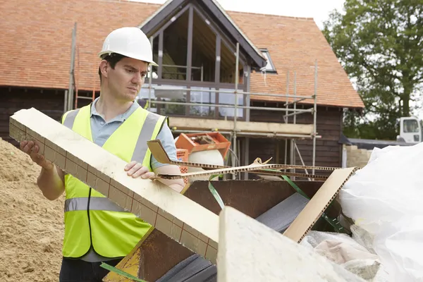 Byggherre som lägger avfall i soporna Skip to Rubbish — Stockfoto