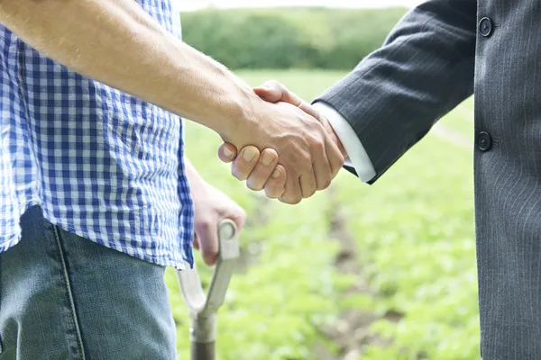 Bonde och affärsman som skakar hand — Stockfoto