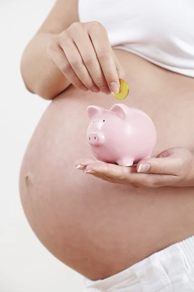Close Up Of Pregnant Woman Putting Coin Into Piggy Bank — Stock Photo, Image