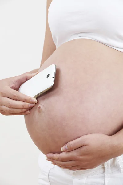 Primo piano della donna incinta che tiene il telefono cellulare per urtare — Foto Stock