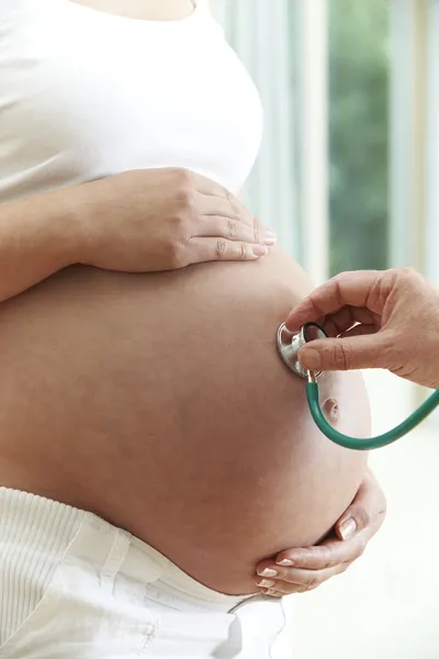 Врач проверяет здоровье беременной женщины — стоковое фото