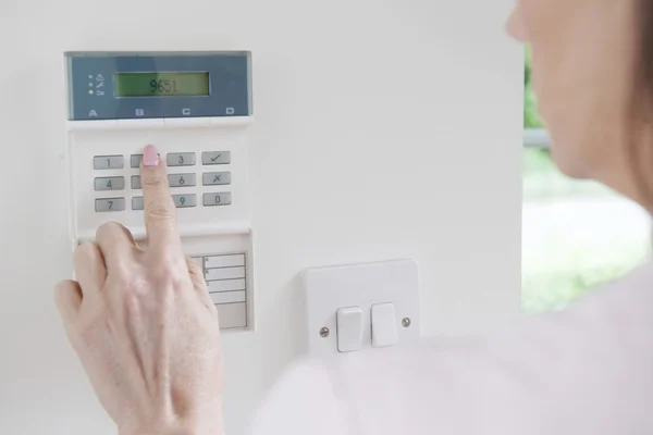 Kobieta ustawienia panelu sterowania system bezpieczeństwa w domu — Zdjęcie stockowe