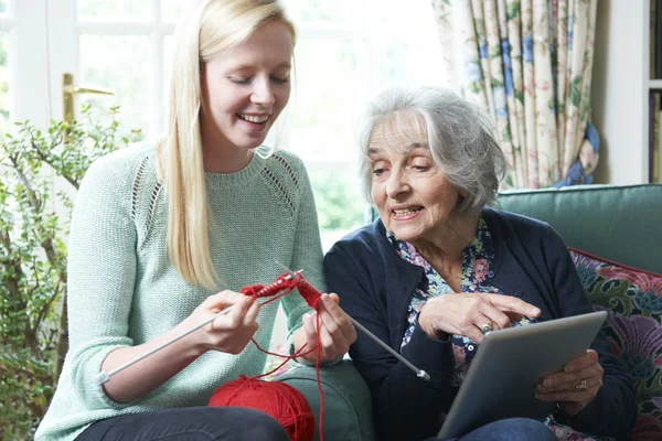 Großmutter strickt mit digitalem Tablet — Stockfoto