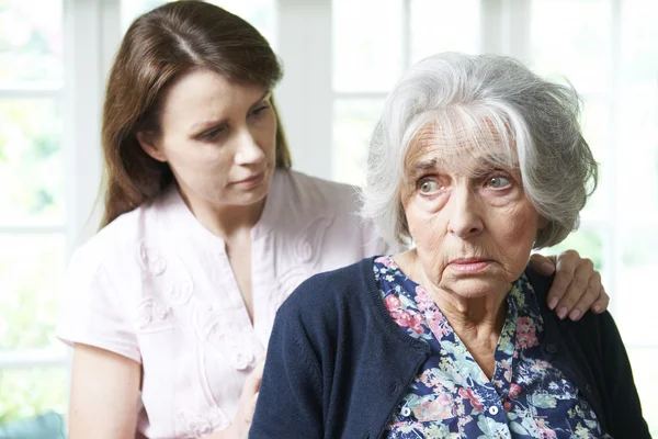 Hija adulta consolando a la madre mayor en casa —  Fotos de Stock