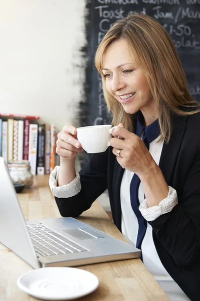 Affärskvinna med laptop i café — Stockfoto