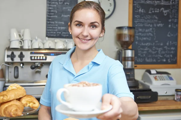 Официантка в кафе, обслуживающая клиента с кофе — стоковое фото