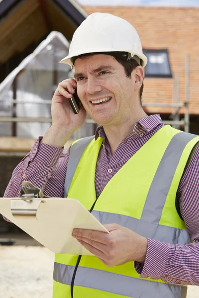 Arquitecto en el sitio del edificio usando teléfono móvil — Foto de Stock