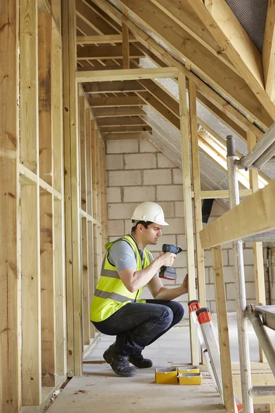 Trabajador de construcción usando taladro en la construcción de la casa — Foto de Stock