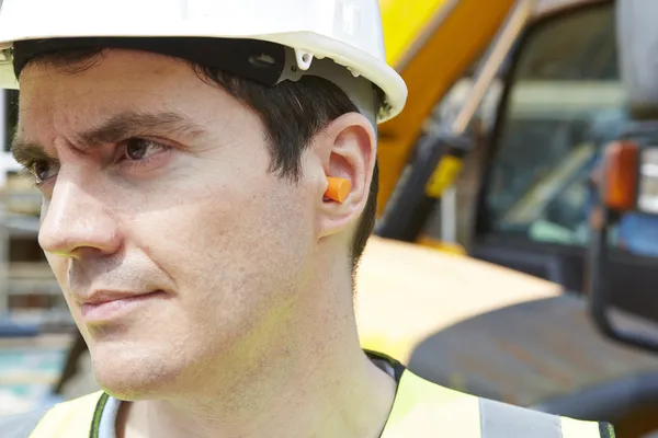 Trabajador de la construcción con tapones protectores para el oído — Foto de Stock