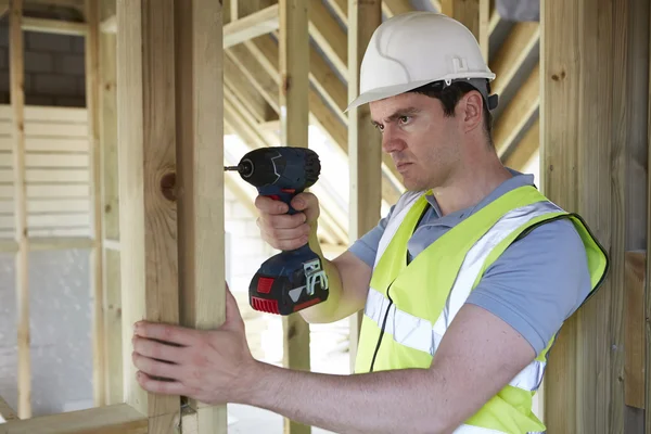 Trabajador de la construcción usando taladro inalámbrico en la construcción de la casa — Foto de Stock