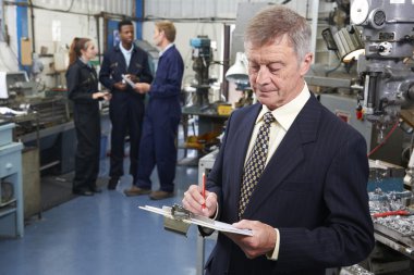 arka planda personeli ile mühendislik fabrika sahibi