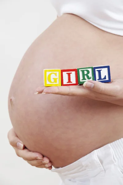 Närbild på gravid kvinna med block stavning baby — Stockfoto