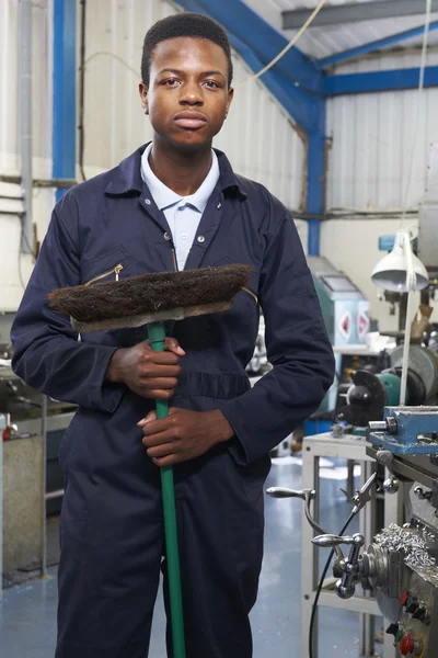 Leerling in engineering fabriek vloer vegen — Stockfoto