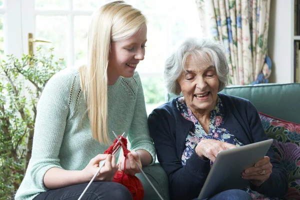 Babcia za pomocą cyfrowego tabletu, jak wnuczka dzianiny — Zdjęcie stockowe