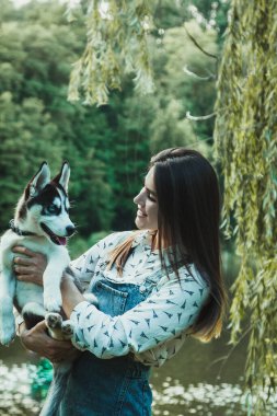Young beautiful girl playing with her cute husky dog pet