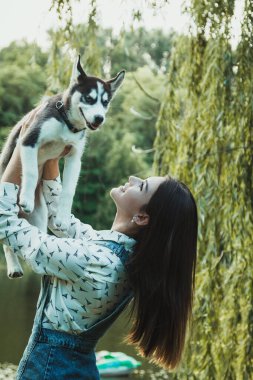 Young beautiful girl playing with her cute husky dog pet 