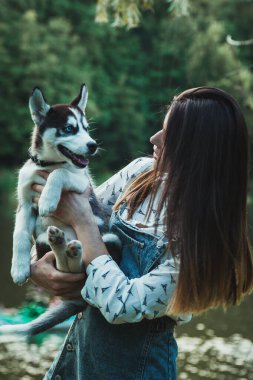 Genç ve güzel kız sevimli köpeğiyle oynuyor. 