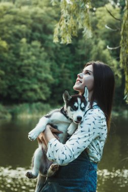 Young beautiful girl playing with her cute husky dog pet 