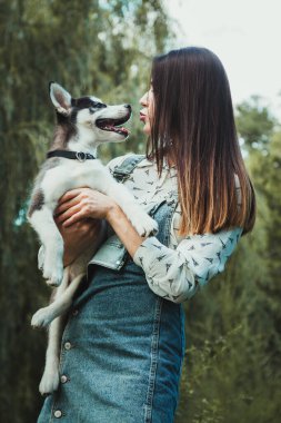Young beautiful girl playing with her cute husky dog pet 