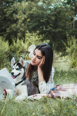 Genç ve güzel kız sevimli köpeğiyle oynuyor. 
